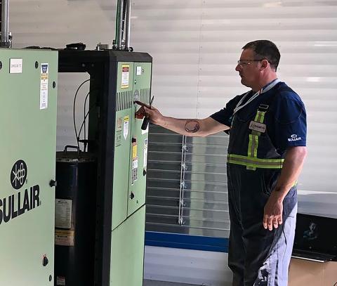 Technician with a Sullair air compressor